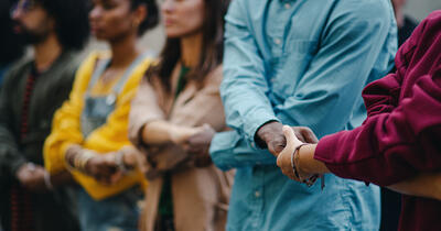 Multiracial group holding hands