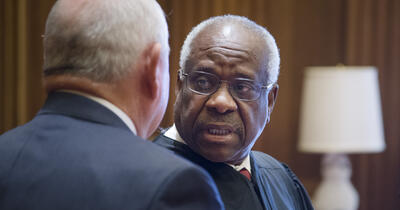 Justice Clarence Thomas speaking with another person