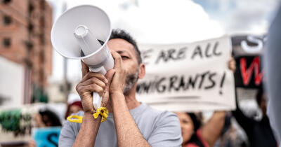 Mature man talking in a megaphone during a protest in the street