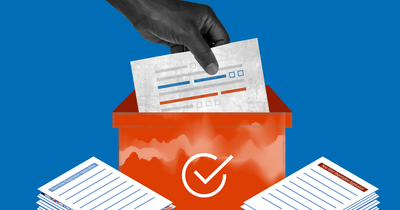 Image of a hand lowering a voter registration sheet into an orange box with stacks of voter registration papers on both sides