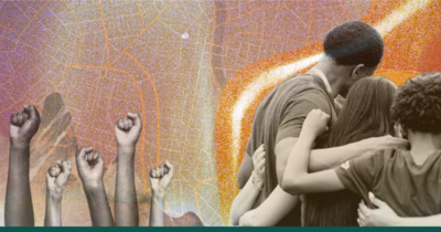 Fists in the air beside a group of people huddled in a circle with arms around each other