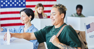 Multiracial Voters Putting Ballots in Bin