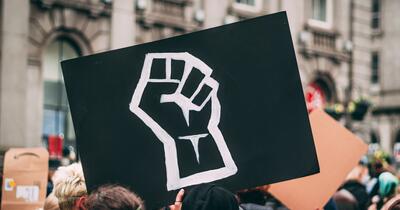 Black sign with a fist in a Black Lives Matter protest
