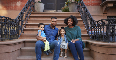 Black family sitting on their front steps