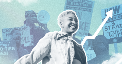 A woman smiling in front of organizers with rally signs 