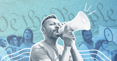 Organizer with a bull horn in front of a rally line