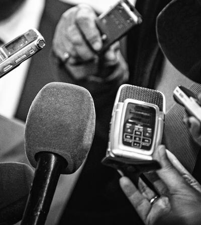 Microphones and recording devices gathered around a person