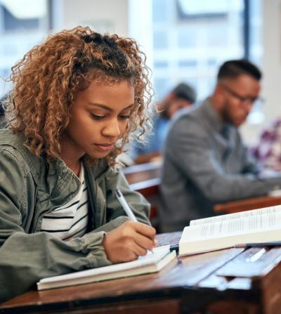 Black student in classroom, writing