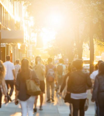 People walking down street at sunset