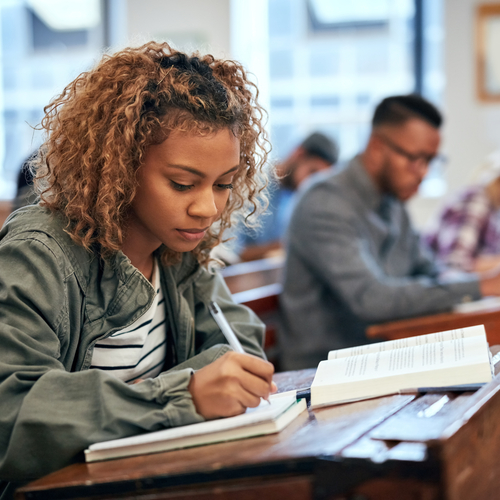 Black student in classroom, writing