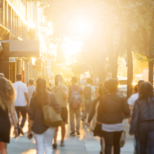 People walking down street at sunset
