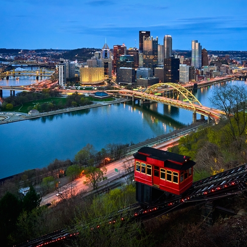 Pittsburgh skyline at dusk from hillside overlooking river