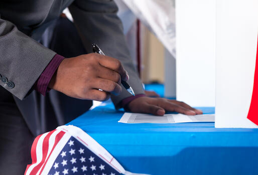 Black voter hovering over a former with a pen