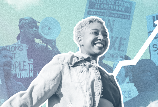 A woman smiling in front of organizers with rally signs 