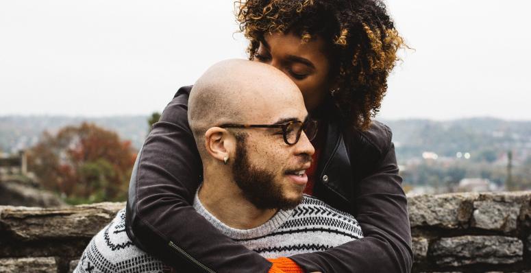 Black couple hugging and looking off into the distance